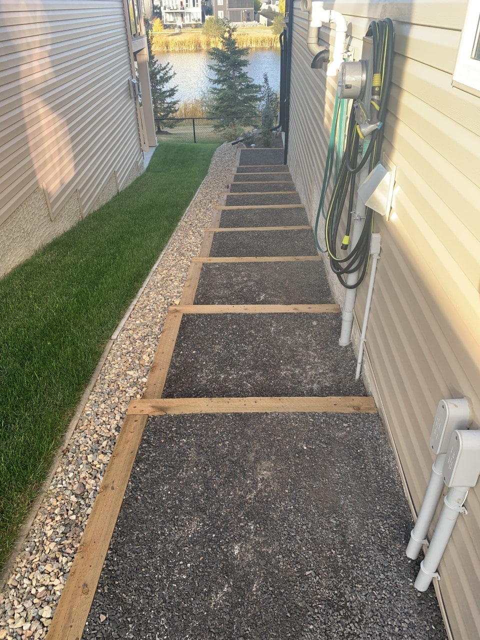 A walkway with steps leading to the side of a house.