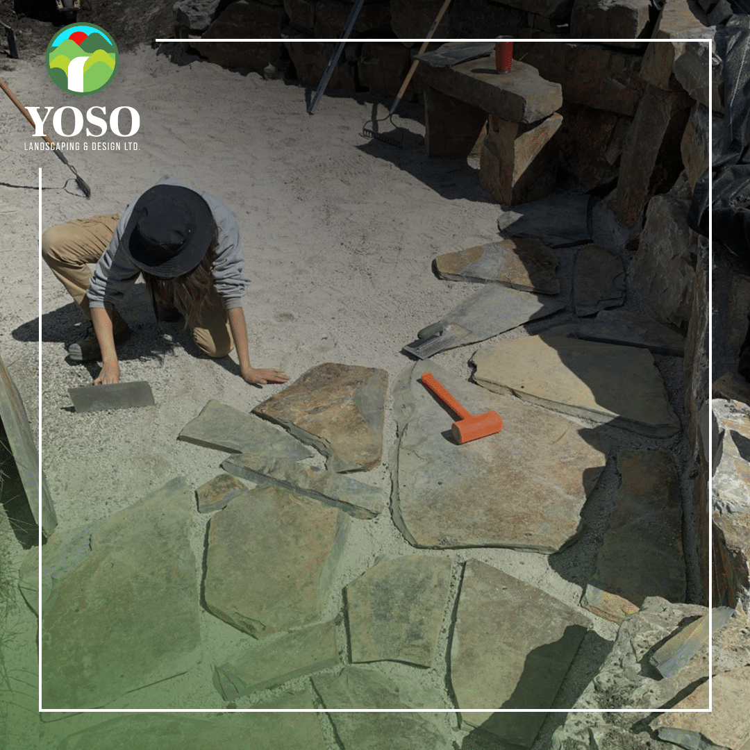 A person is working on the ground with rocks.