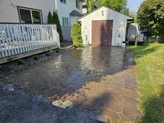 A flooded driveway with water running down the side of it.