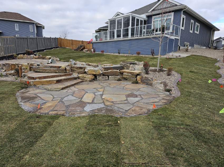 A backyard with a stone patio and steps.