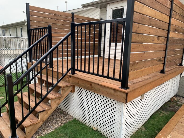 A wooden deck with steps and black railing.